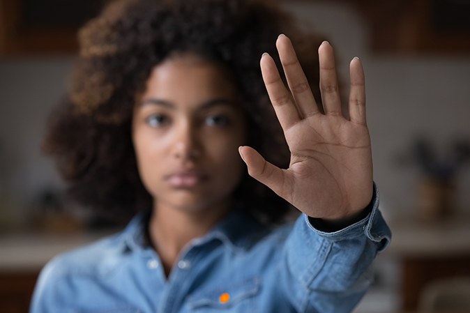 Young woman holding her hand up signaling to stop