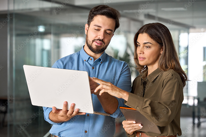 Man and a woman working together on a laptop in an office