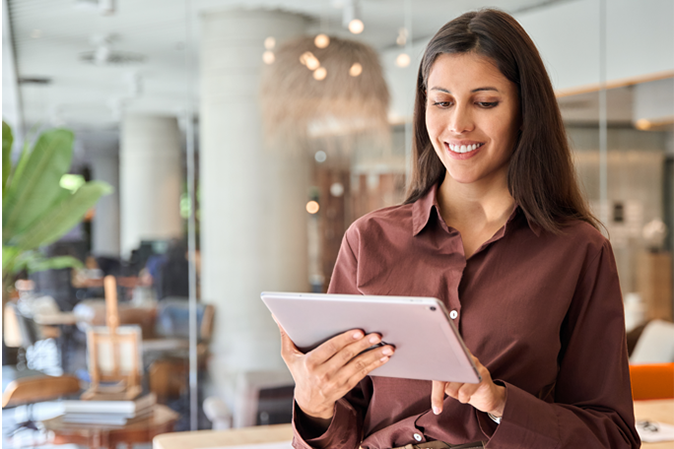 Young woman smiling while working on a tablet